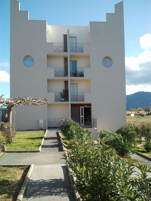 Un bâtiment clair de quatre étages, aux pignons à redents, aux fenêtres circulaires et aux balcons centraux.