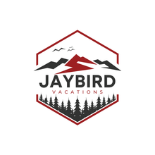 a logo for jaybird vacations with a mountain and trees in a hexagon .