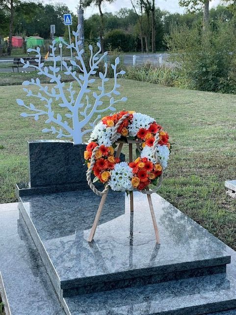 Couronne de fleurs blanches et oranges sur portant