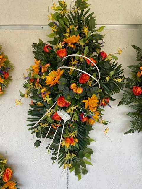 Coussin de fleurs rouges et orange accroché au mur