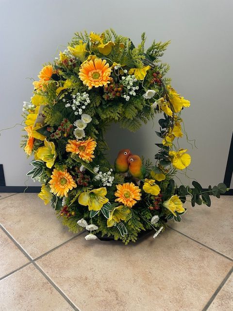 Couronne de fleurs jaunes et oranges en forme de C