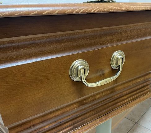 Gros plan d'un cercueil en bois avec une poignée en laiton