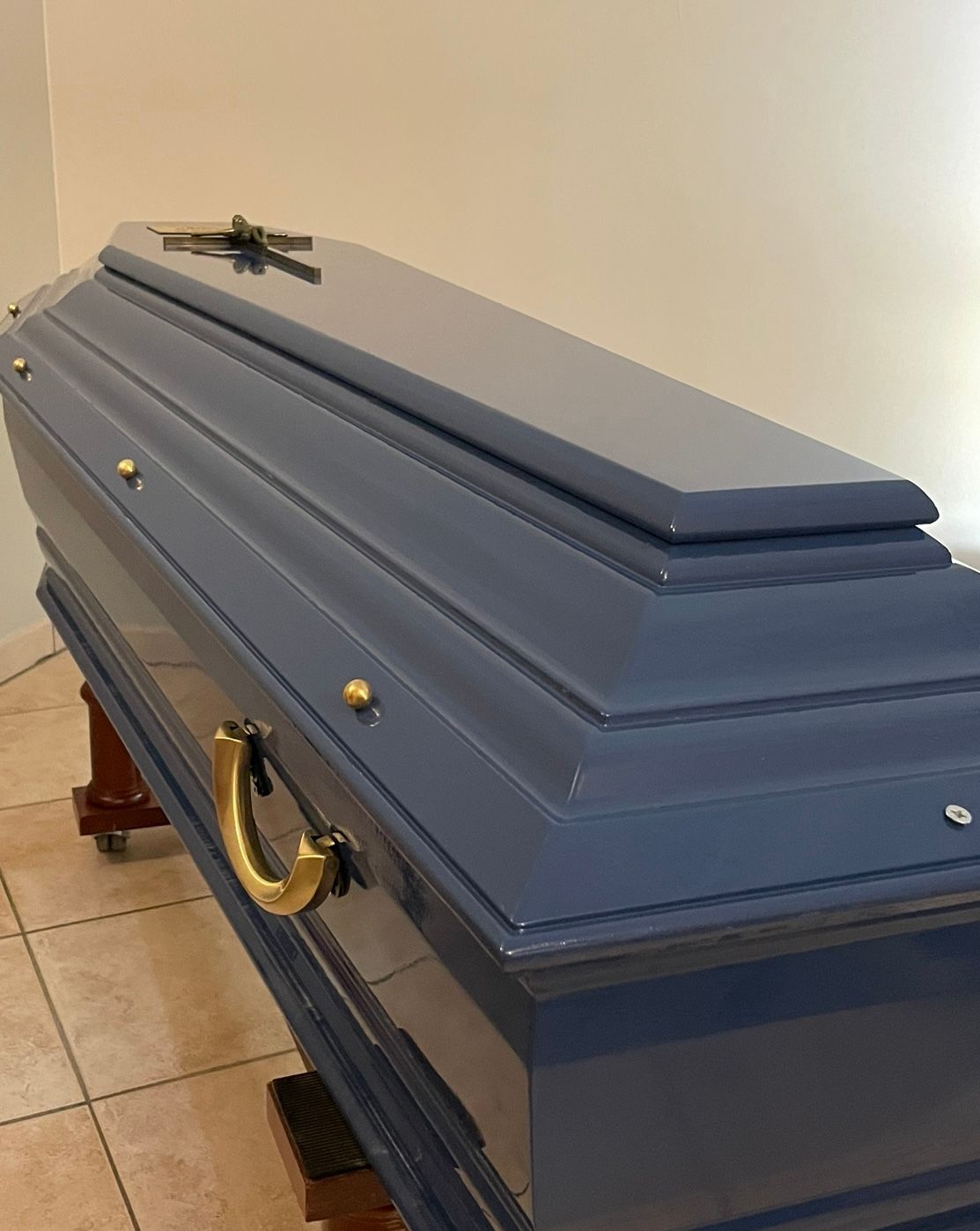 Cercueil bleu avec une croix sur le dessus et avec poignées dorées