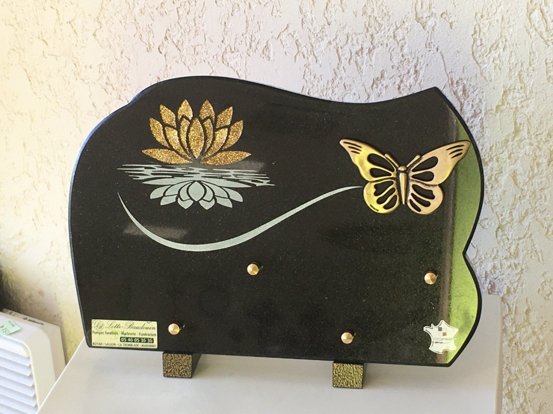 Plaque gravée avec papillon et lotus dans l'eau