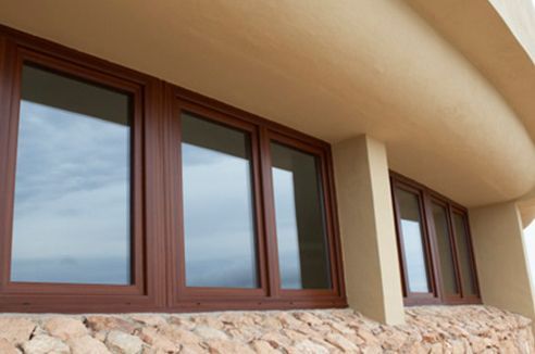 Un edificio con muchas ventanas y una pared de piedra.