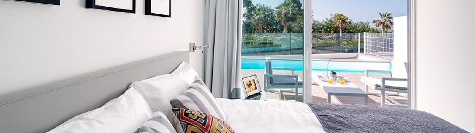 Un dormitorio con una cama y una puerta corrediza de vidrio que conduce a una piscina.