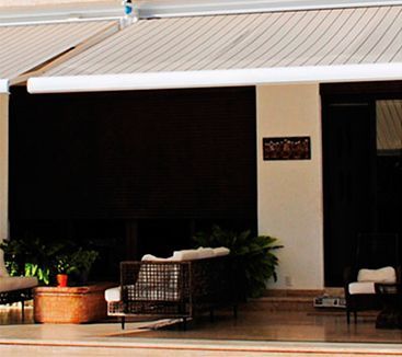 Un patio con muebles y un toldo blanco sobre él.