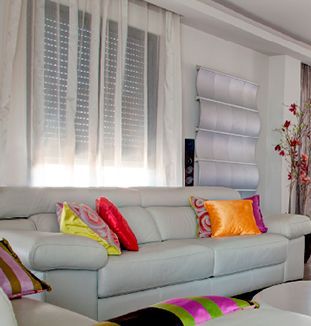 Una sala de estar con un sofá blanco y almohadas de colores.