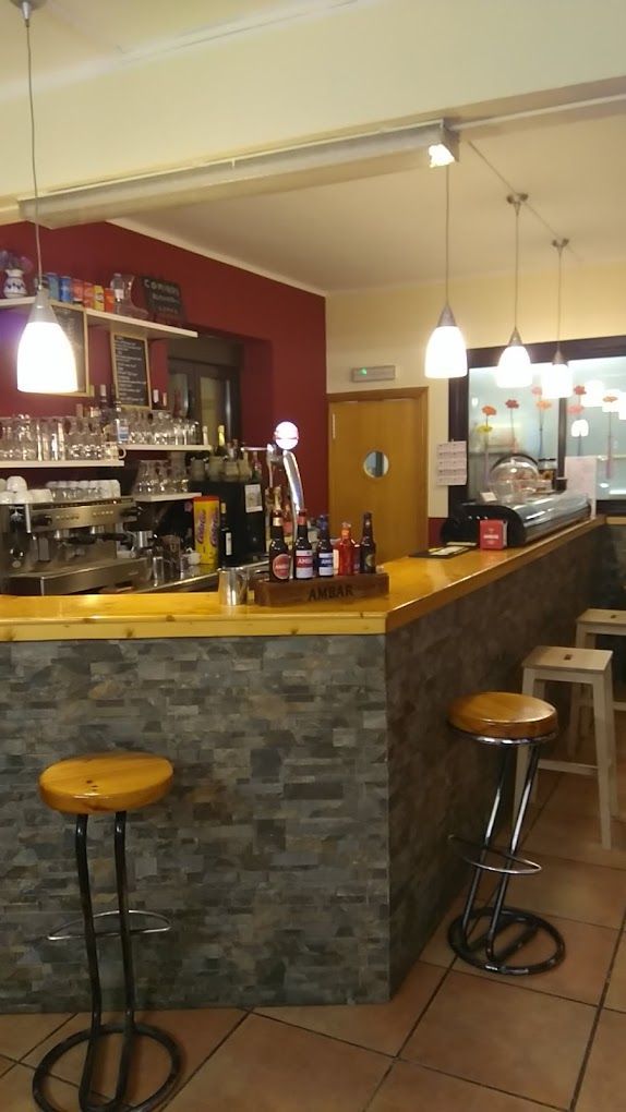 Un bar con mostrador de madera y taburetes en un restaurante.