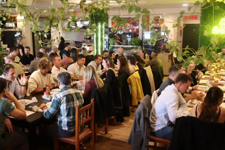Plates of salad with tomatoes, lettuce, and cheese on a table in a restaurant