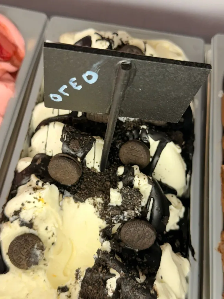 Vaso de helado Oreo decorado con trozos de galleta y el logo negro de Oreo en un recipiente transparente.