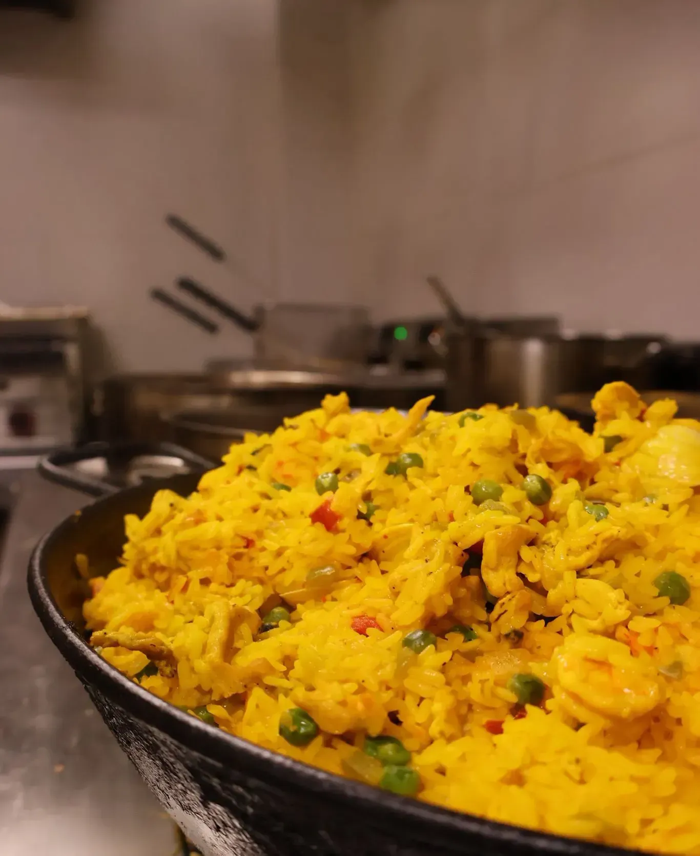 Primer plano de una gran sartén negra llena de arroz frito con cúrcuma .