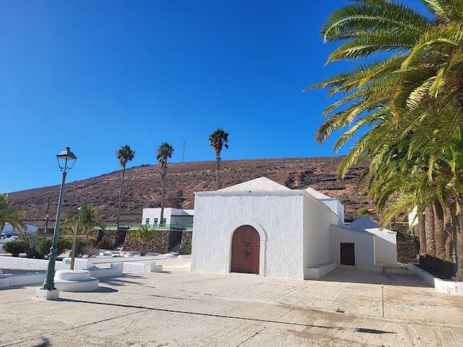 Un edificio blanco con palmeras delante.