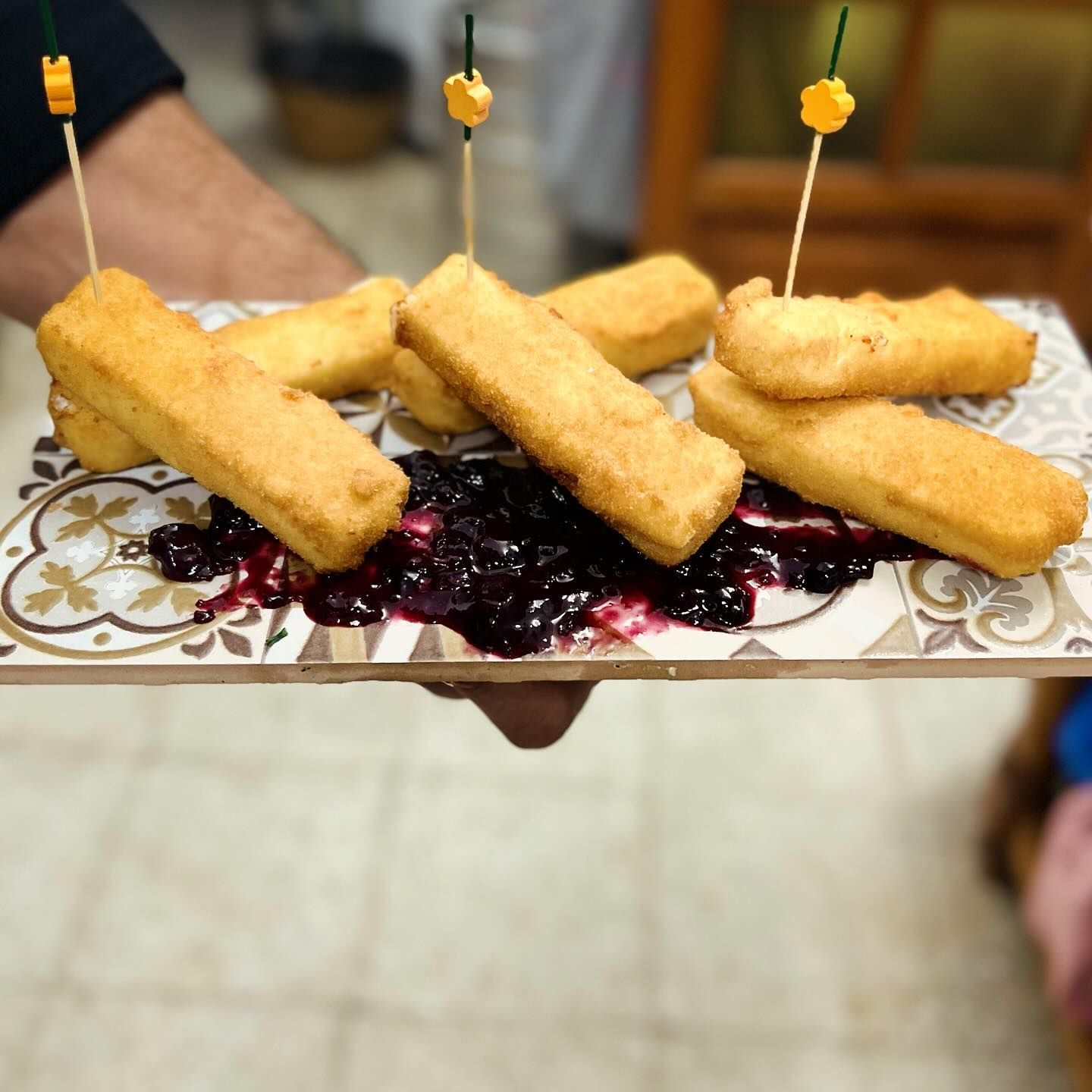 Una persona sostiene un plato de comida con palillos dentro.