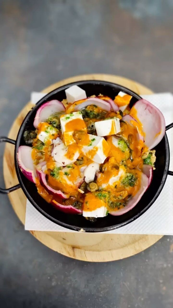 Un primer plano de un plato de comida sobre una tabla de cortar de madera.