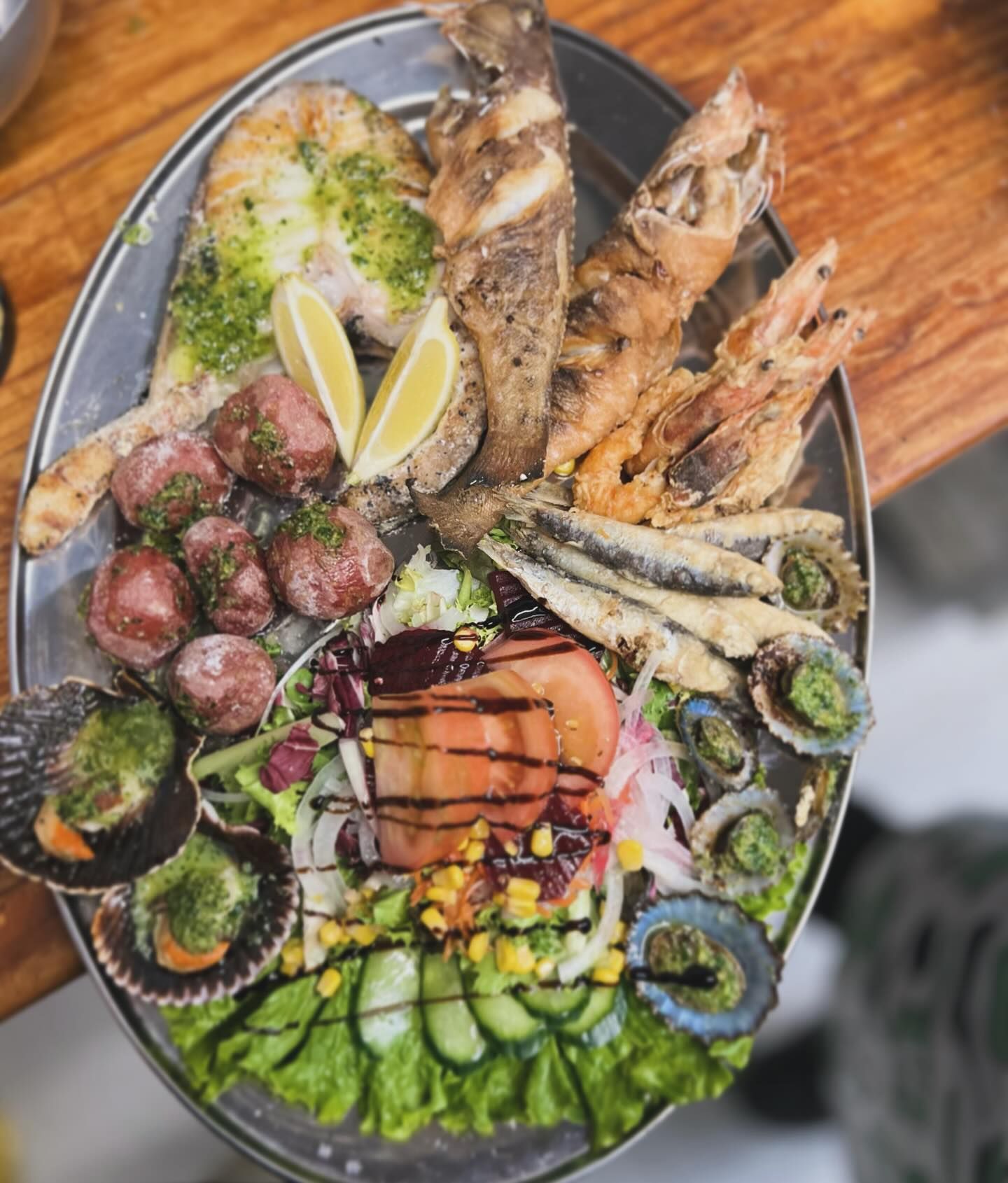 Un plato de comida con verduras y pescado en una mesa.