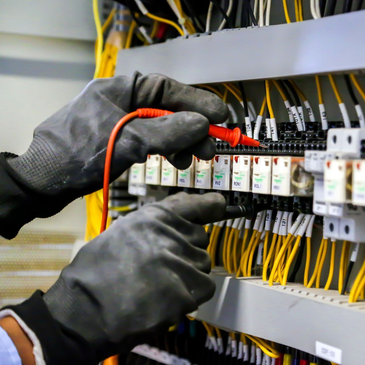Un technicien mesure la tension dans un tableau électrique