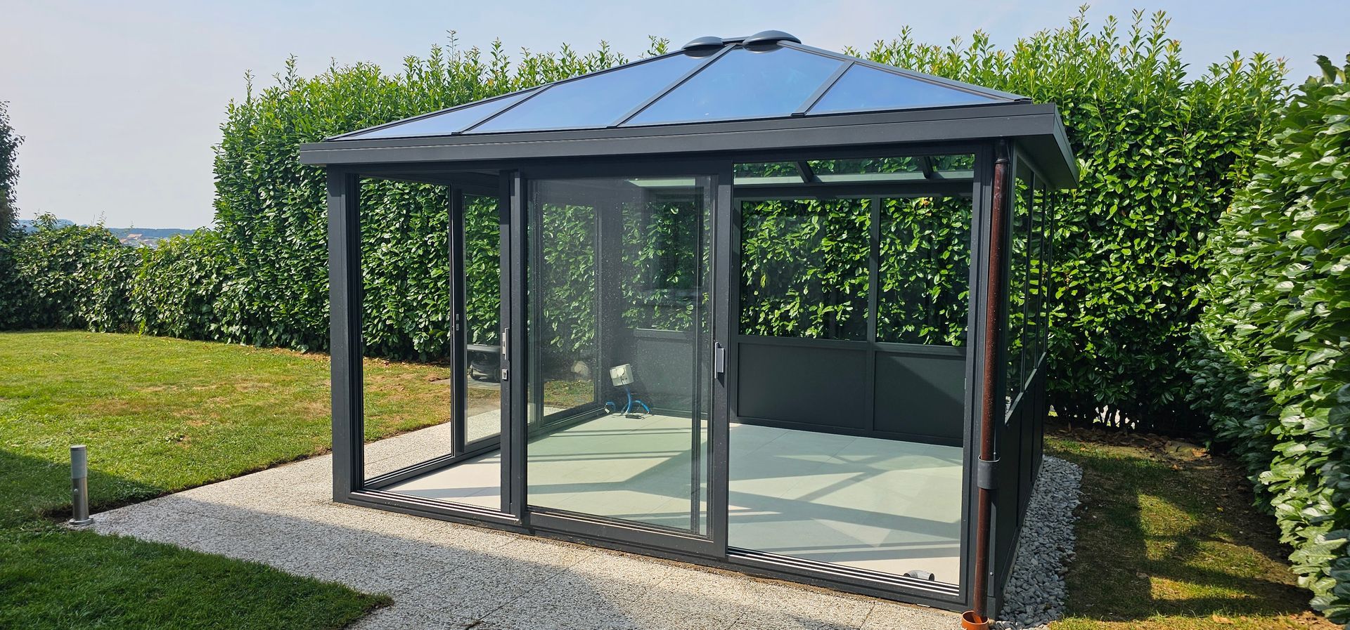 Vue intérieure d'une pièce avec des lambris sur le mur de droite et un plafond et un sol blancs.