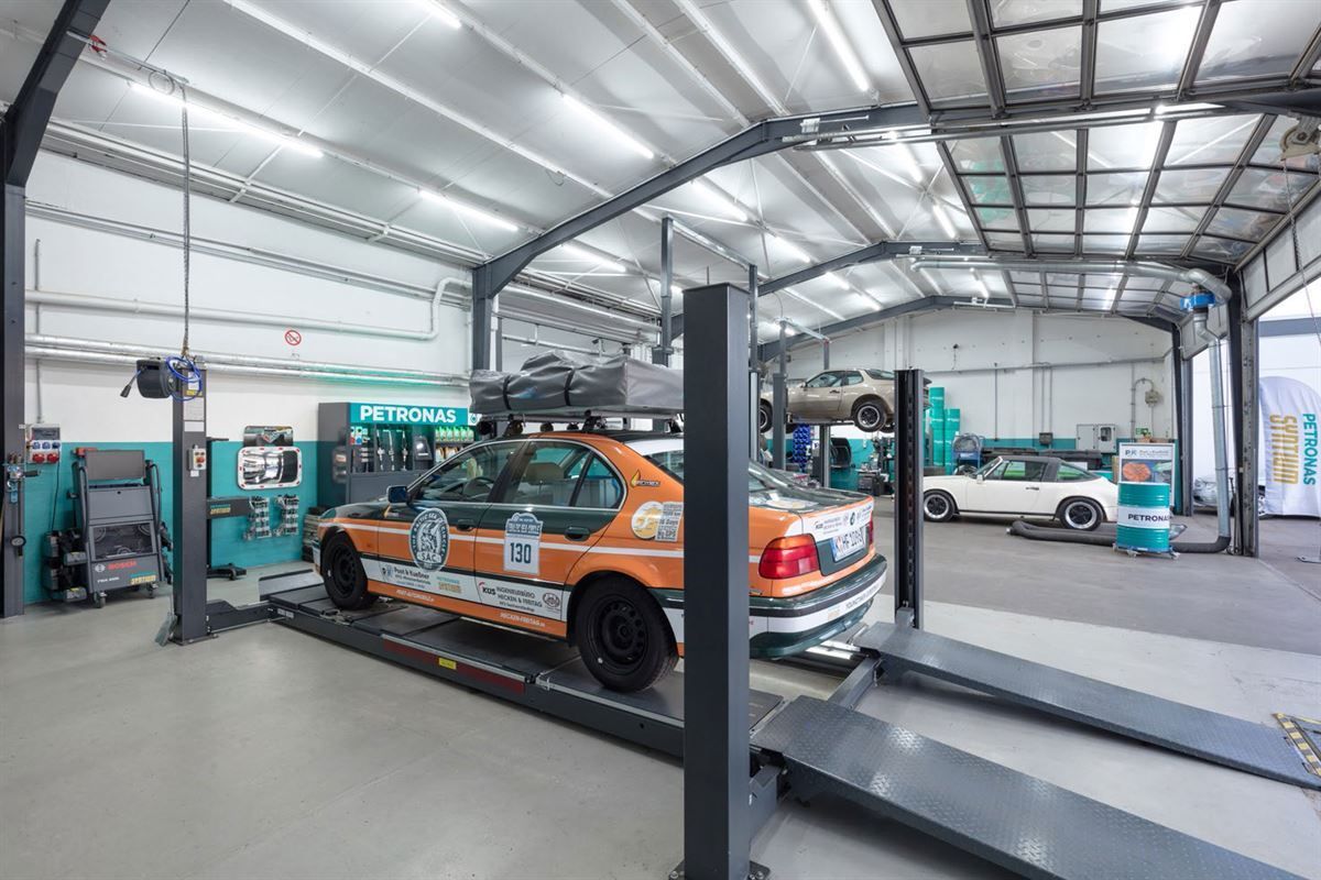 Ein Rennwagen steht auf einer Hebebühne in einer Garage