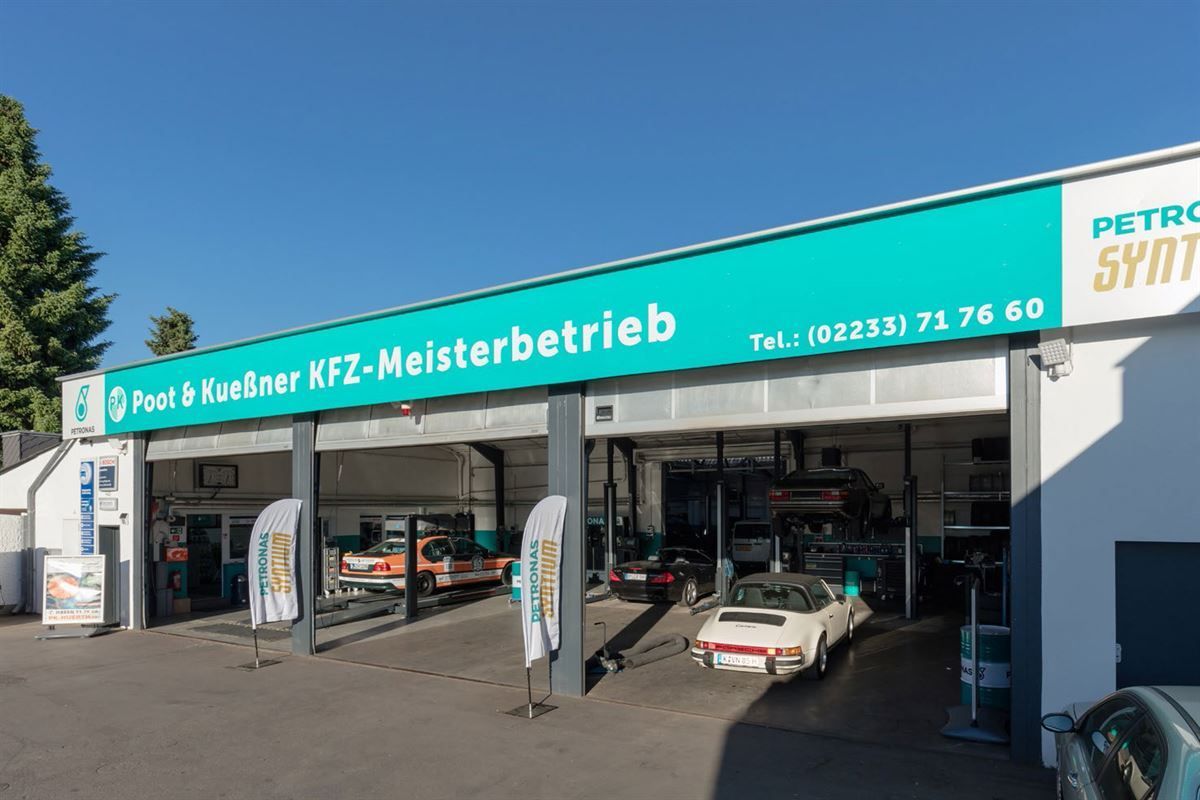 Ein weißes Auto steht vor einer Petro-Synt-Garage