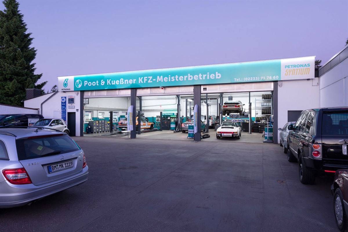 Eine Reihe von Autos parken vor einer Autowerkstatt