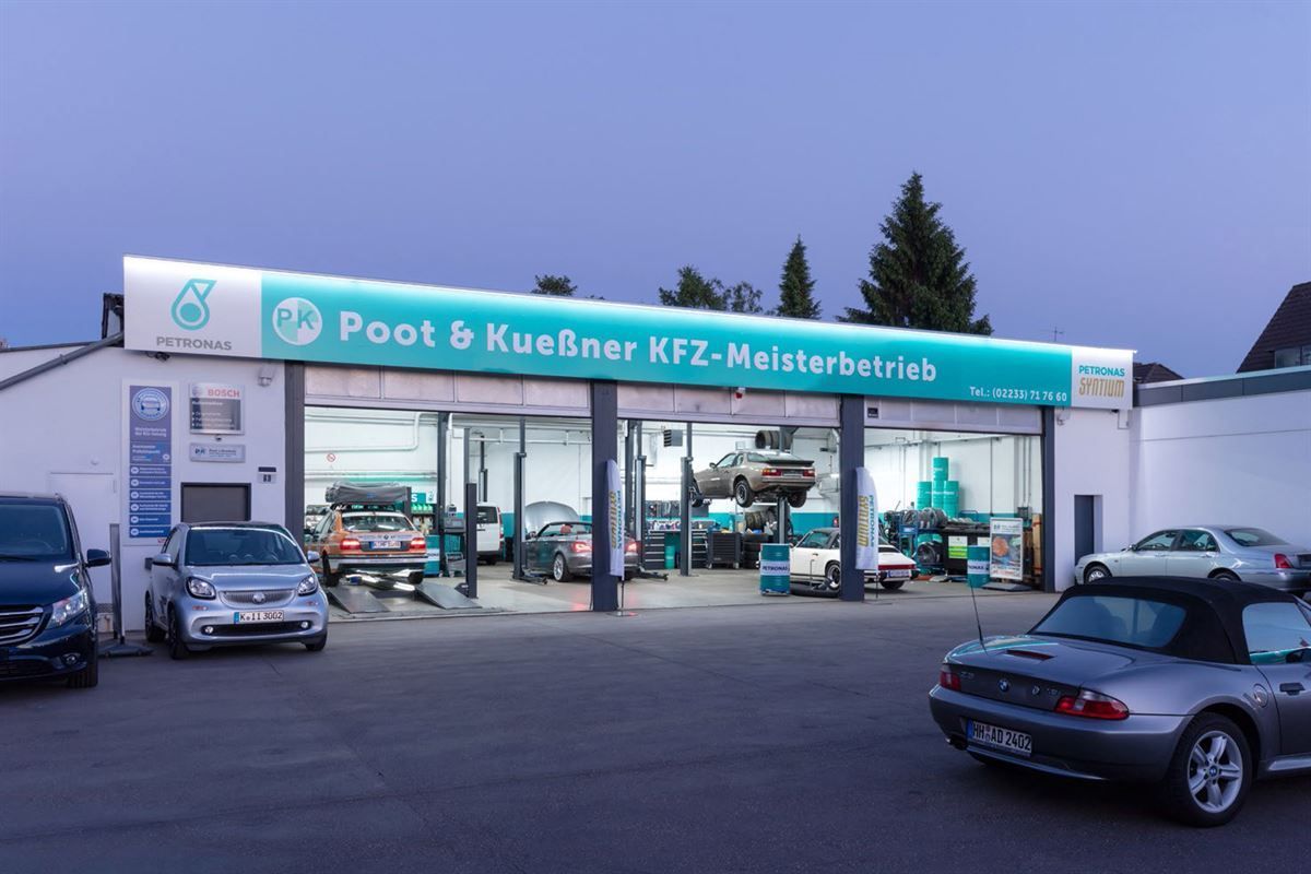 Several cars are parked in front of a poot & kuebner kfz-meisterbetrieb