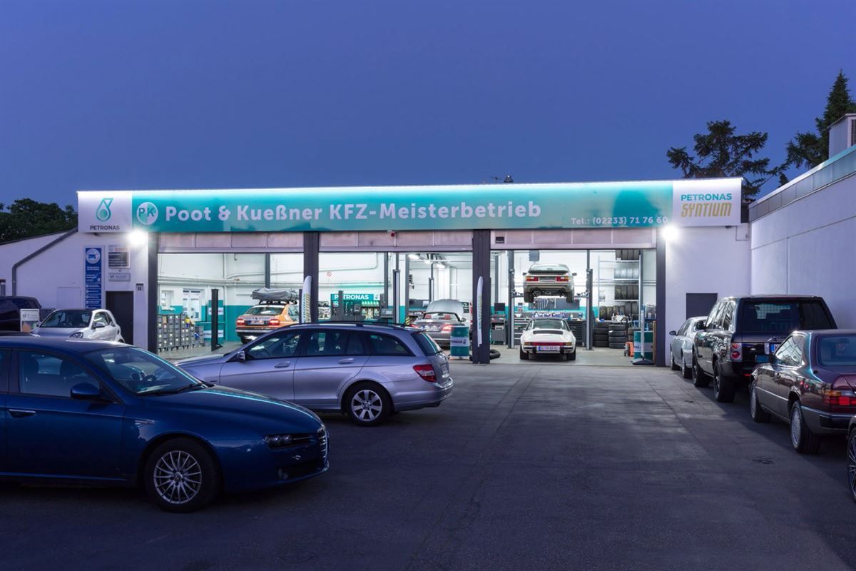 Several cars are parked in front of a poot & runnner kfz-meisterbetrieb