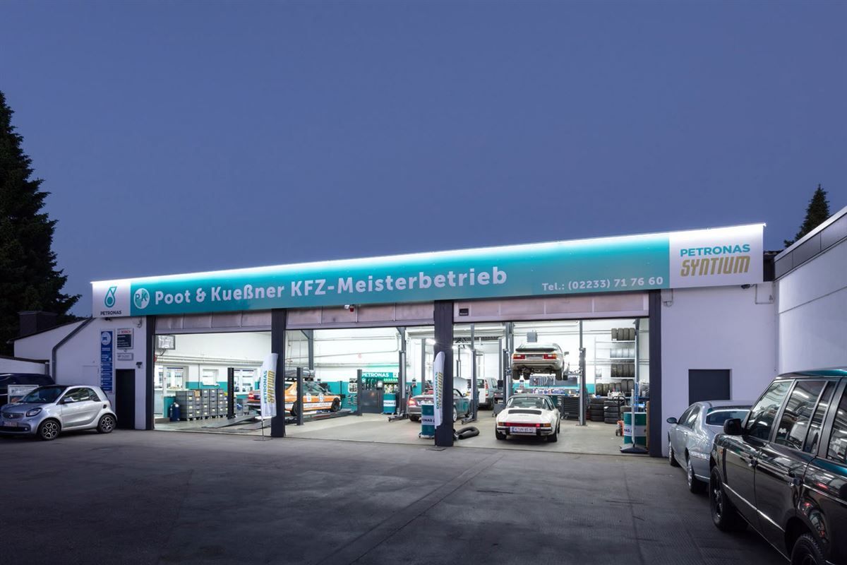 Ein paar Autos stehen vor einem Gebäude mit der Aufschrift 