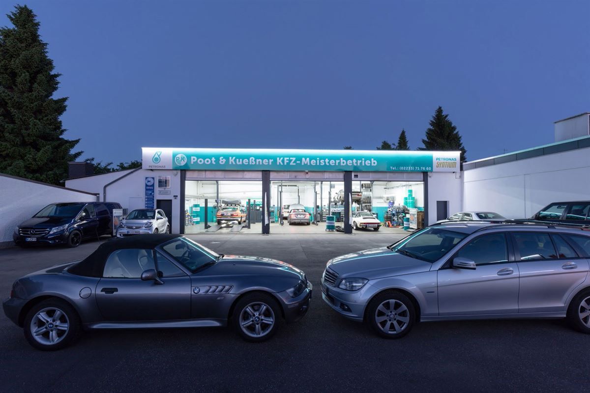 Zwei Autos stehen vor einem Gebäude mit der Aufschrift Paul