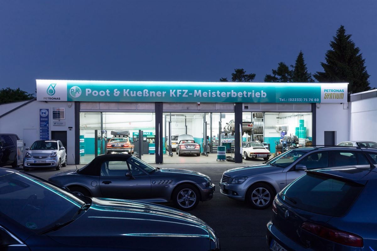 A lot of cars are parked in front of a poot & kuebner kfz-meisterbetrieb
