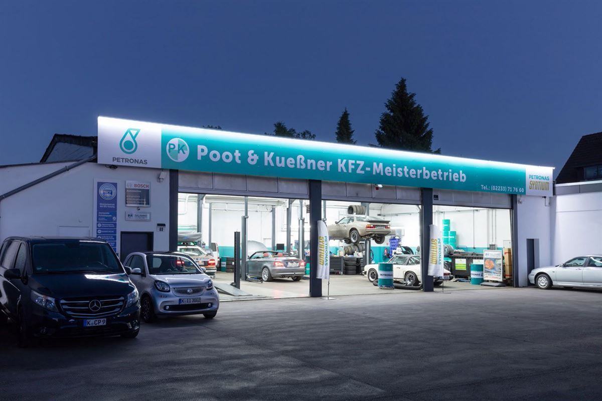 Cars are parked in front of a poot & kuenner kfz-meisterbetrieb