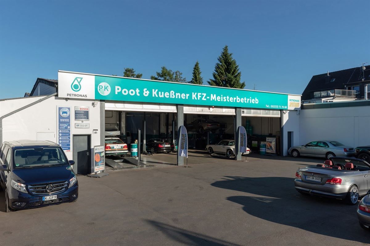 Autos parken vor einem Gebäude mit der Aufschrift „Poot & Kuebner“