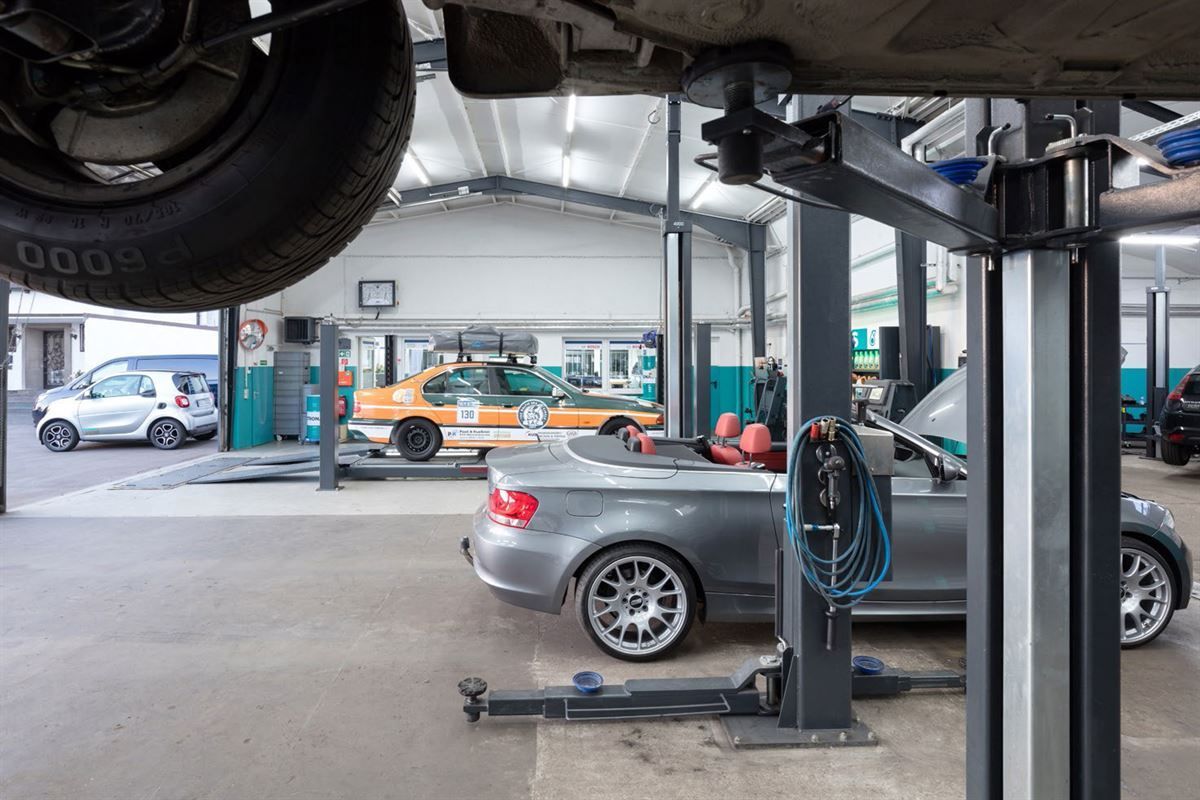 Ein Auto steht mit einem guten Jahresreifen auf einer Hebebühne in einer Garage
