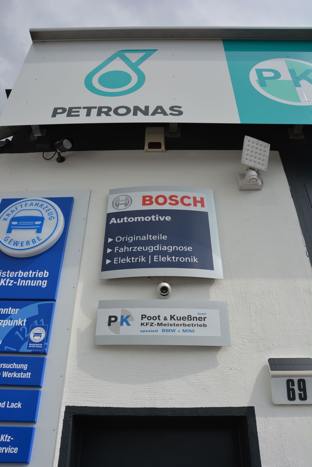 Ein Petronas-Schild über einem Bosch-Schild