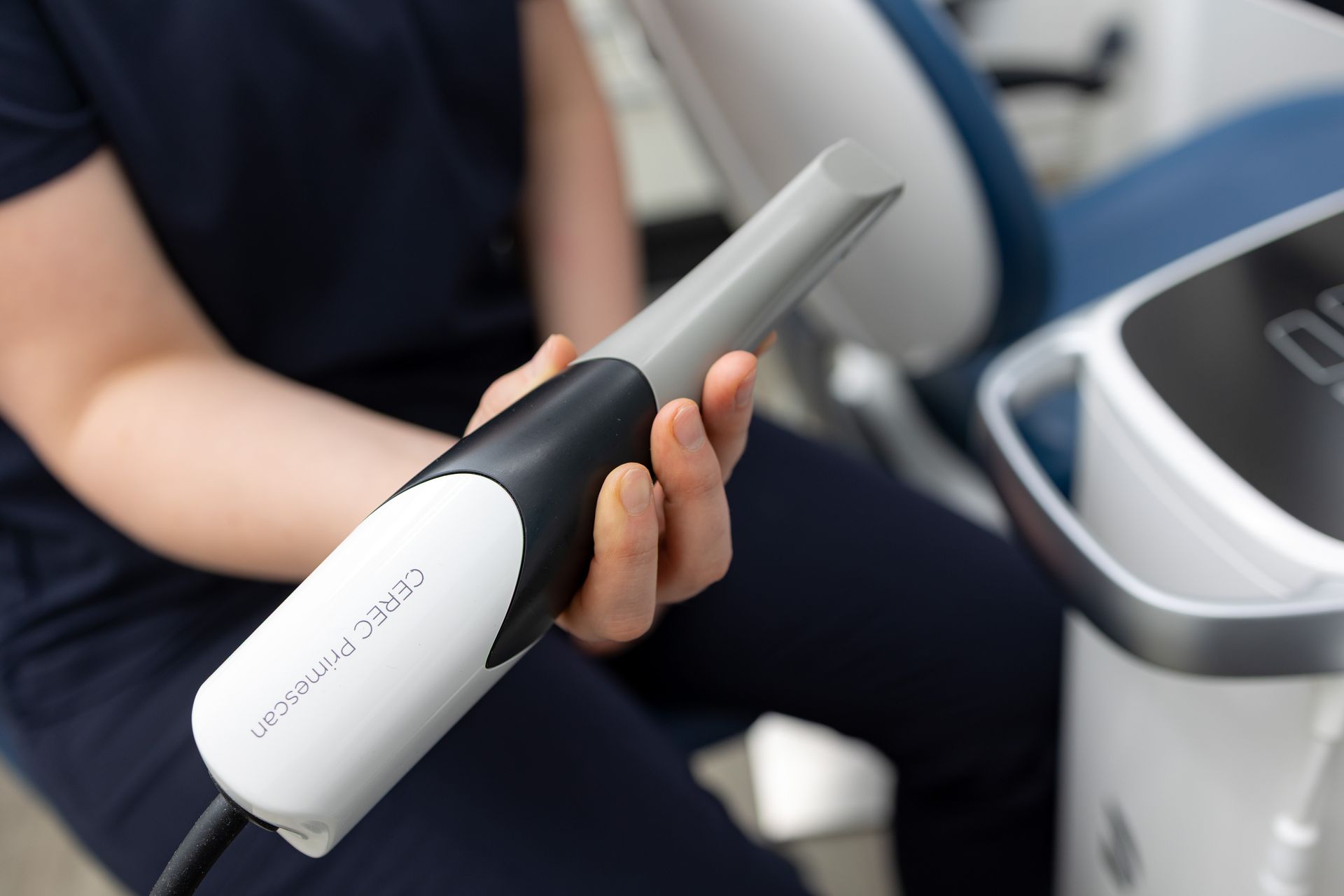 Zahnarzt hält einen Intraoralscanner, ein Werkzeug für digitale Zahnabdrücke.