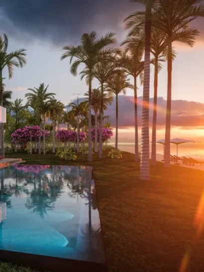 Piscina del resort al atardecer con palmeras, agua que refleja y el resplandor del horizonte oceánico.