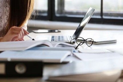 Une personne travaillant à un bureau avec un ordinateur portable.