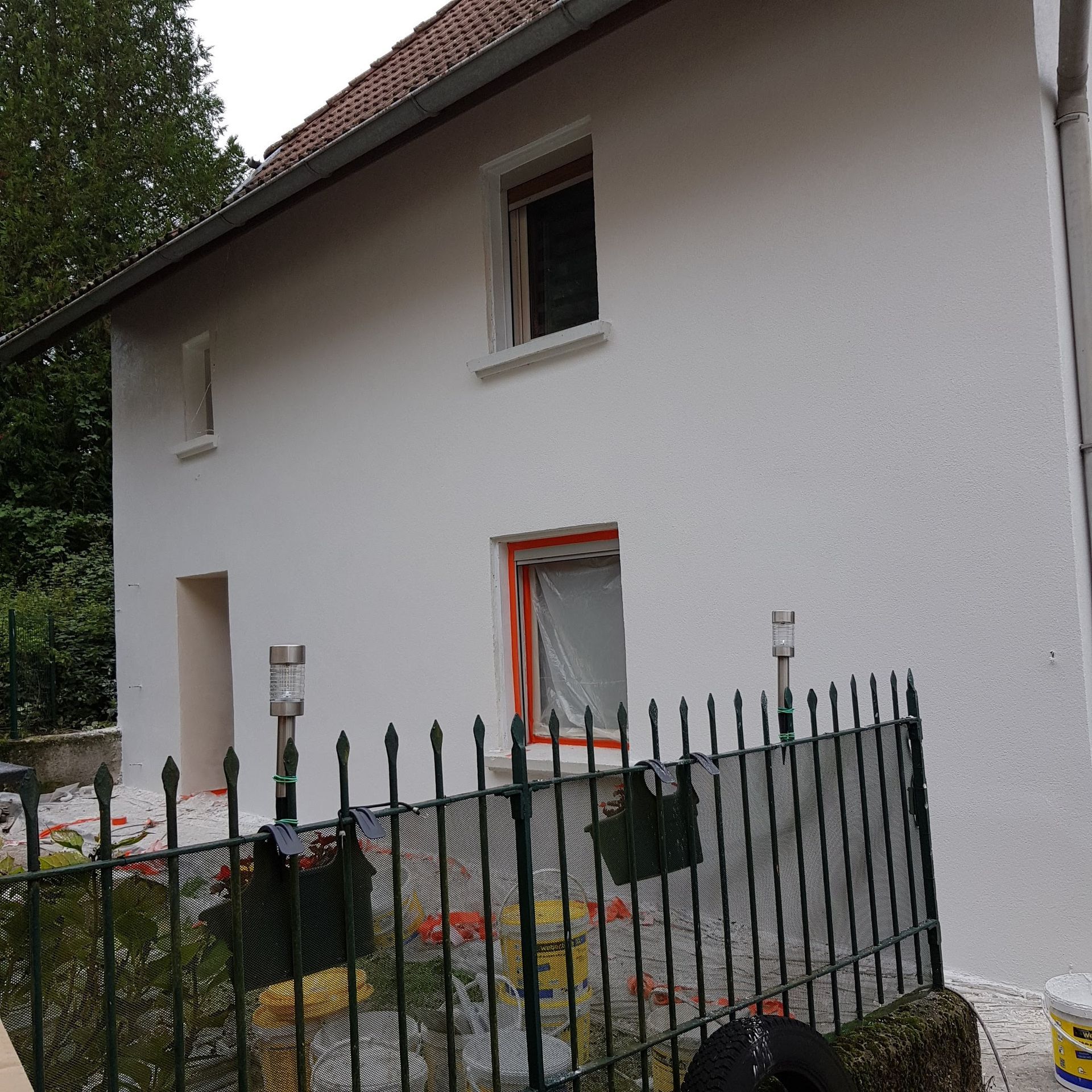 Façade de maison blanche avec grille de clôture