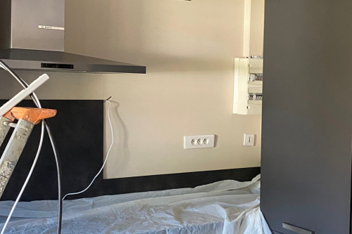 Une cuisine avec une cuisinière, un four et une planche à repasser.