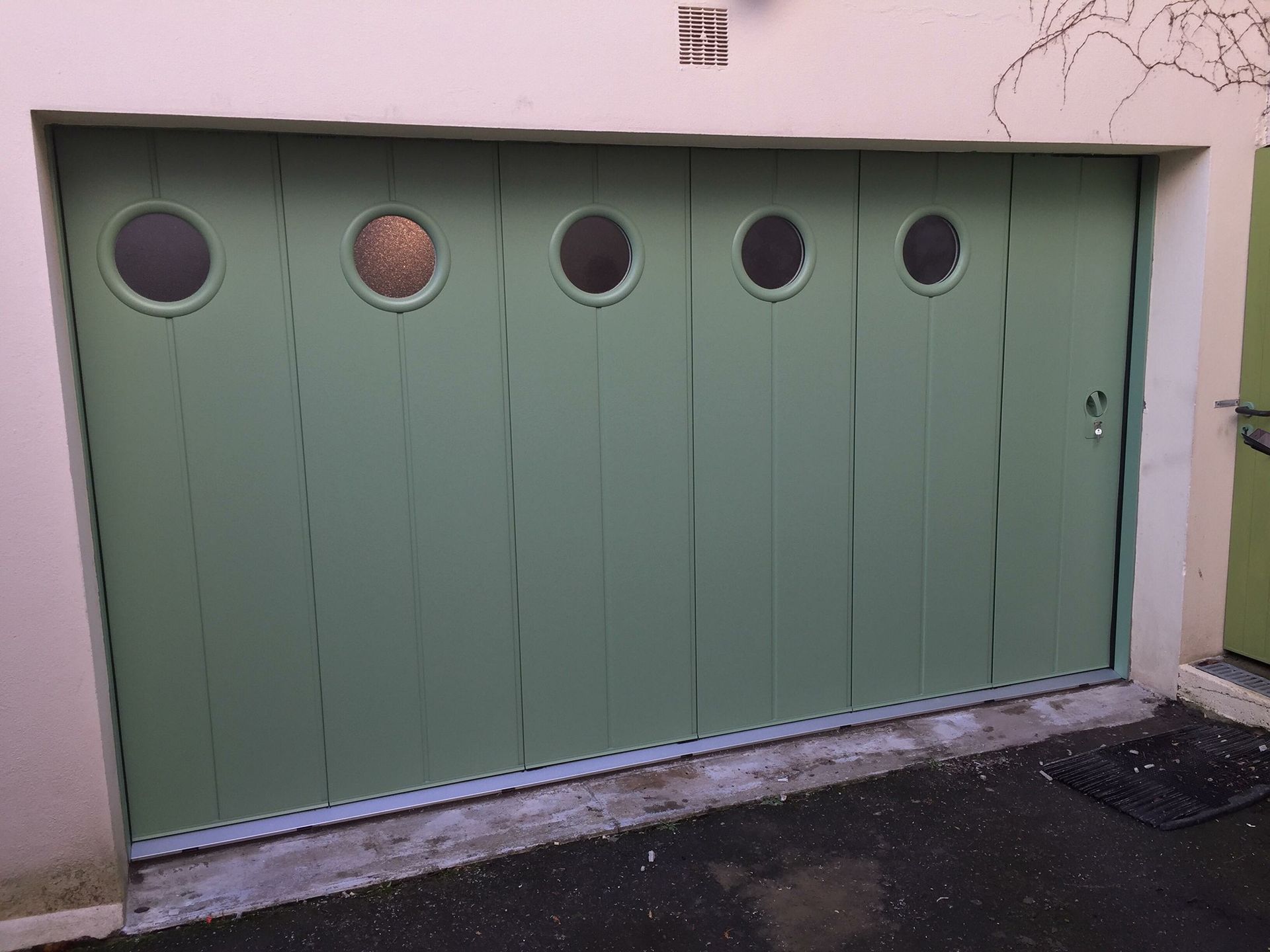 Porte de garage avec fenêtre opaque circulaire