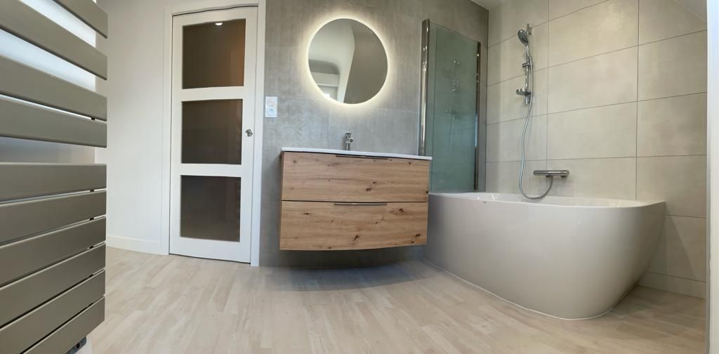 Salle de bains avec lavabo en face et baignoire sur la gauche