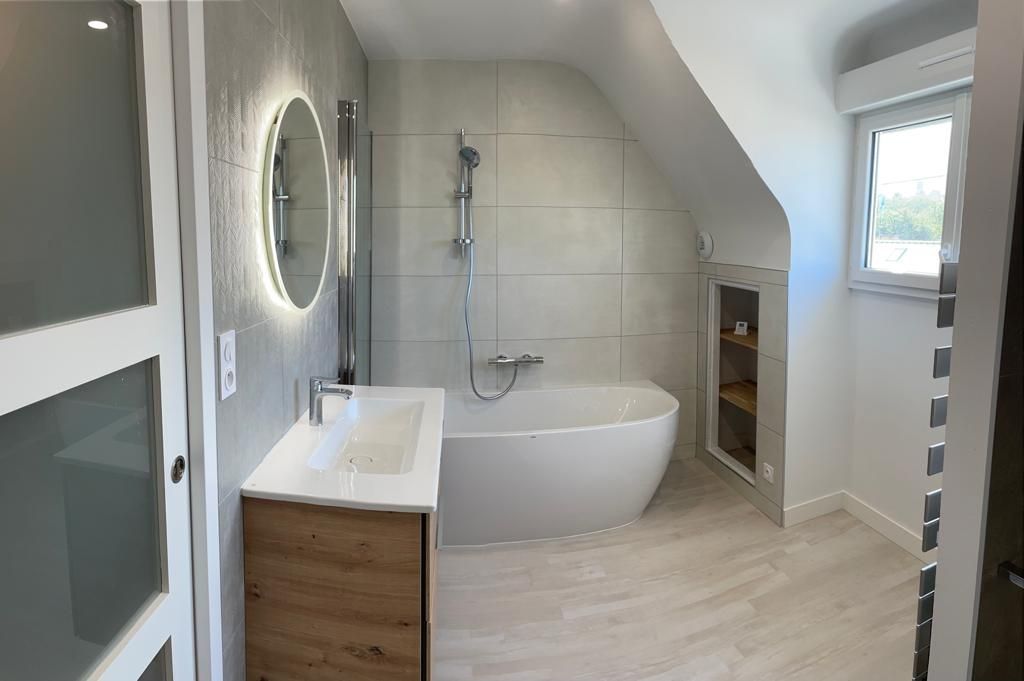 Salle de bains avec miroir et baignoir en fond