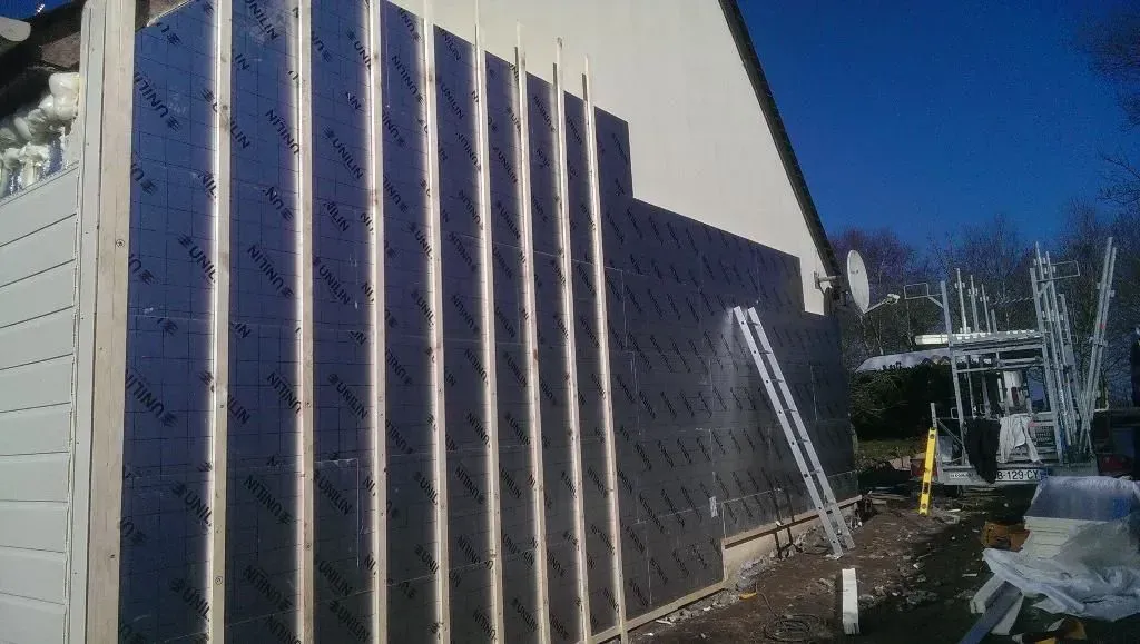 Maison vu de côté avec réalisation de pose d'isolant et échelle adosser au mur