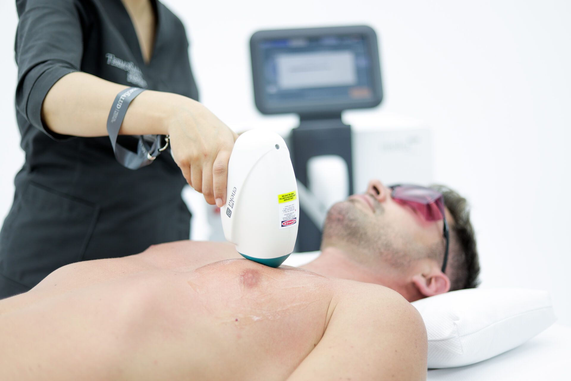 Mujer en lencería blanca, de pie con la mano en el muslo, sobre un fondo blanco.