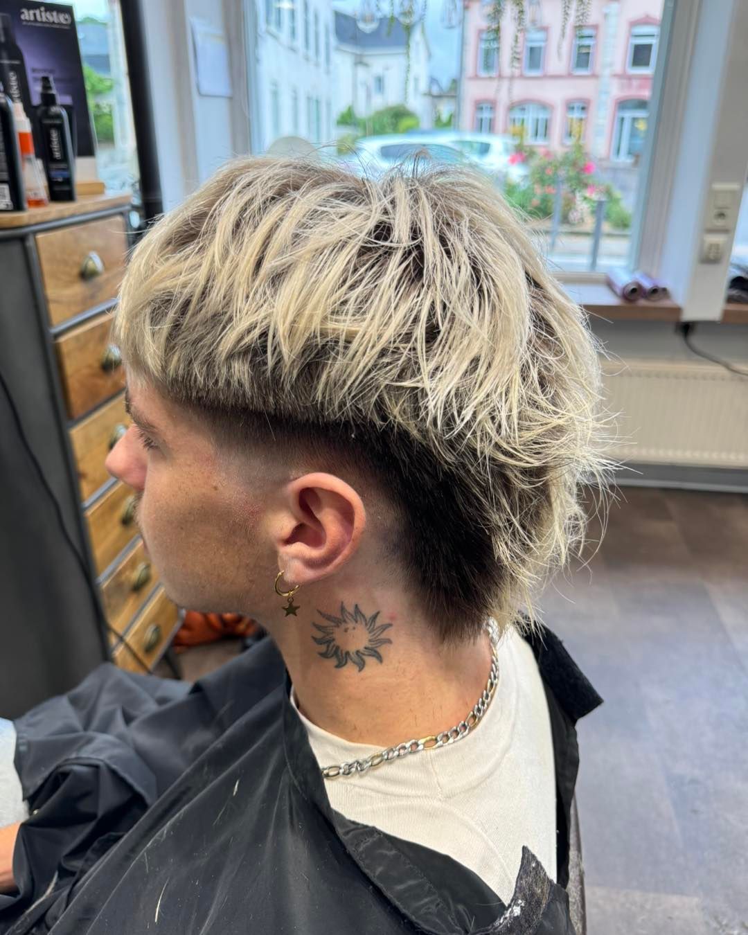 Mèches blondes sur coupe d'homme vue de côté.