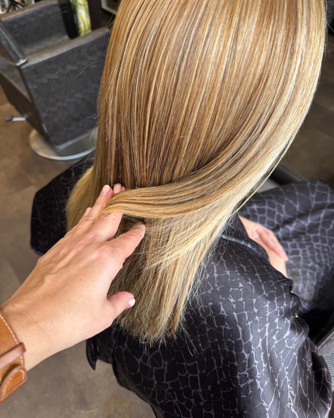Main de la coiffeuse dans les cheveux d'une cliente