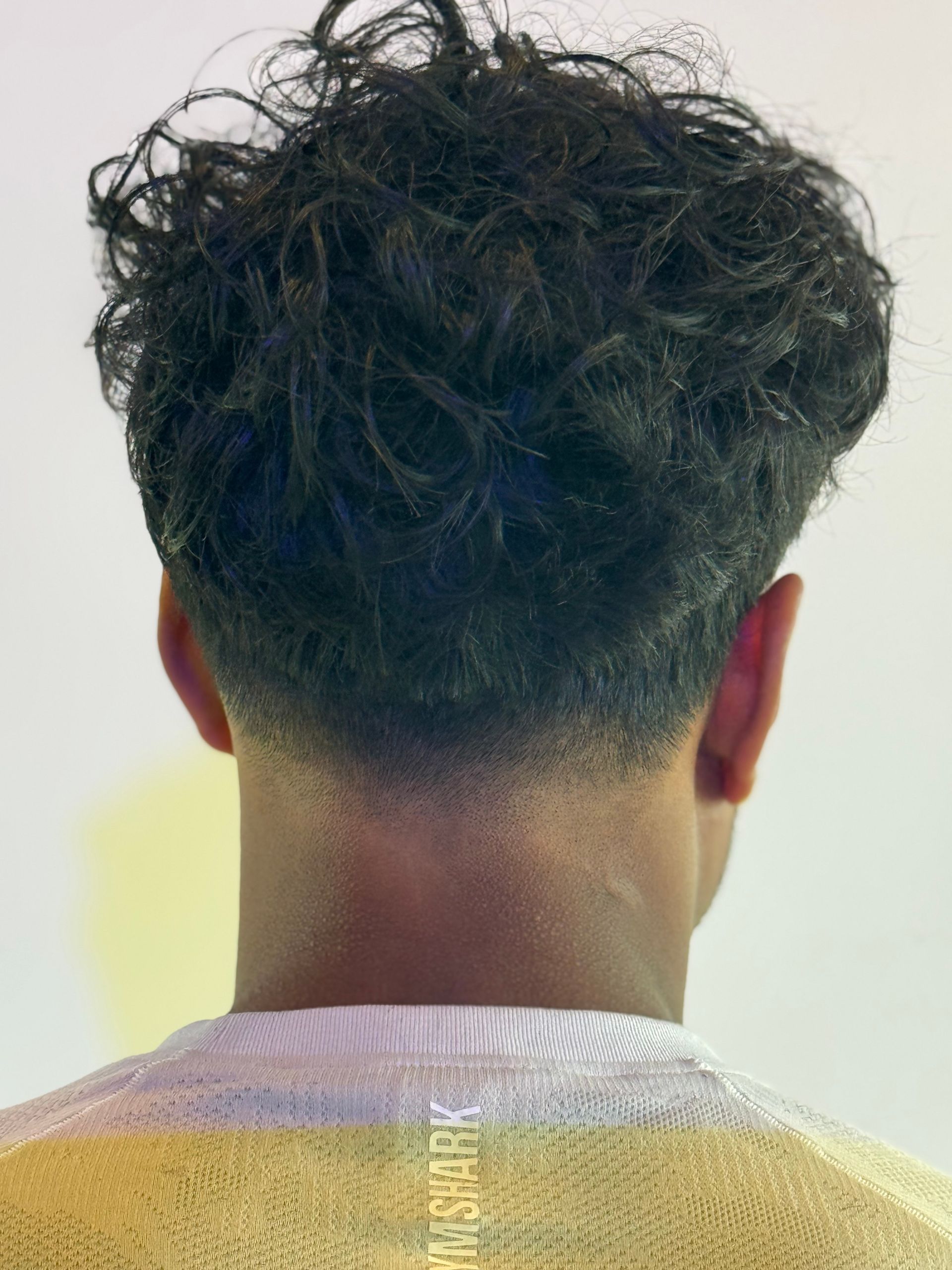 Un homme brun vu de dos.