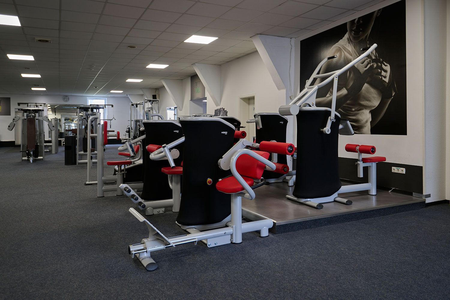 Ein Fitnessstudio mit einem Bild eines Mannes an der Wand