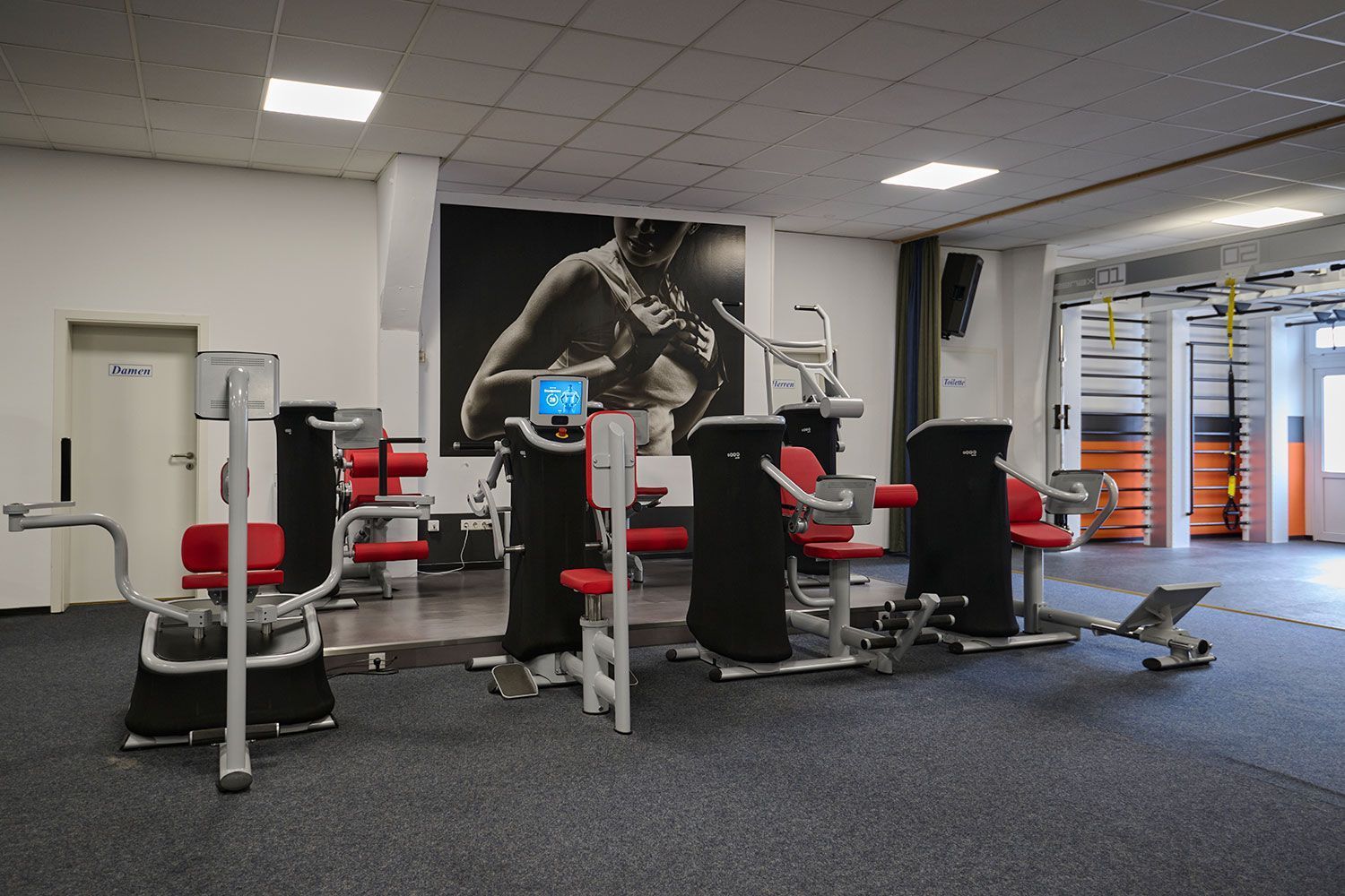 Ein Fitnessstudio mit einem Bild eines Boxers an der Wand.