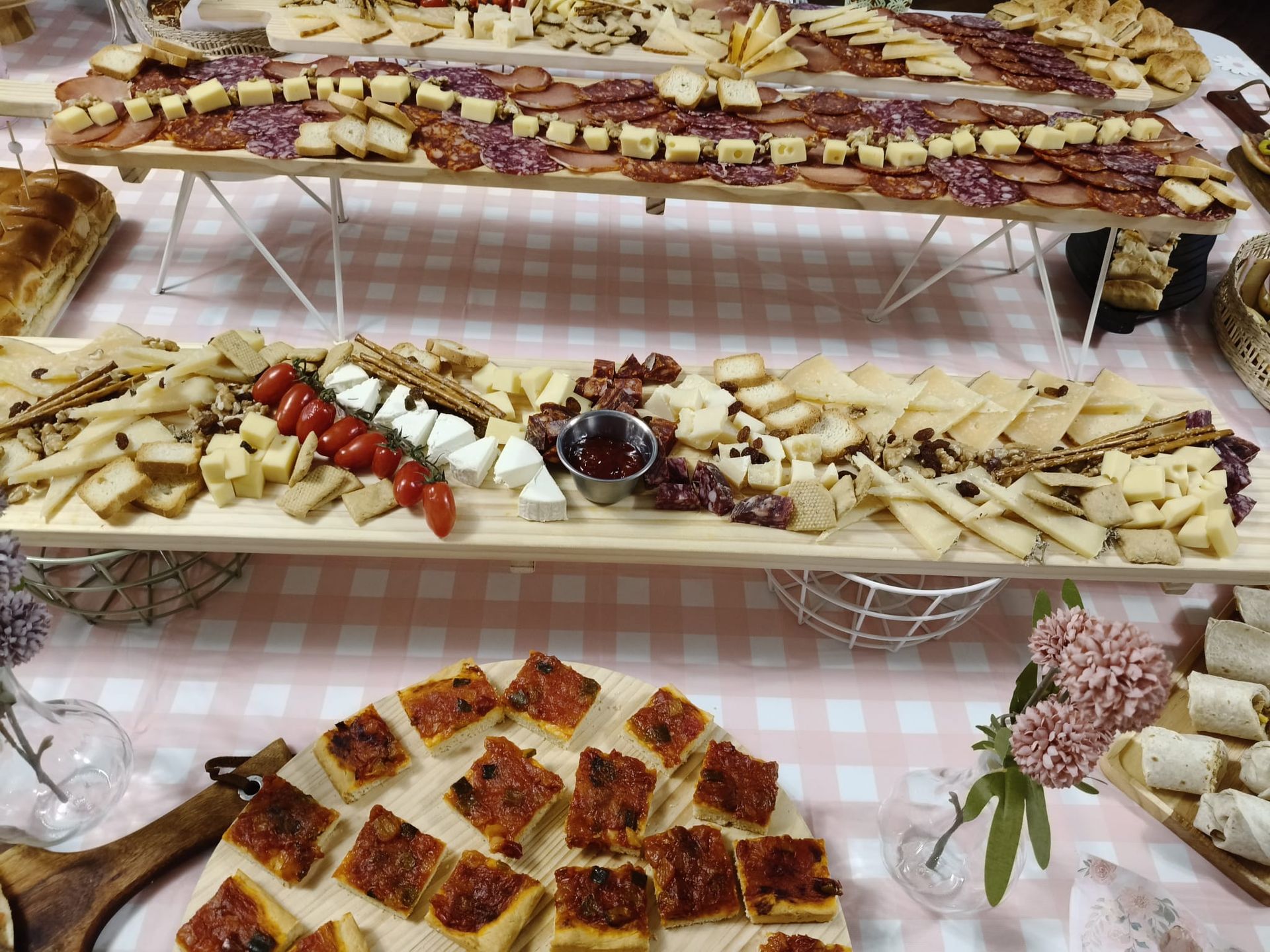 Una tabla de cortar de madera llena de queso, uvas y un gran surtido de ibéricos.